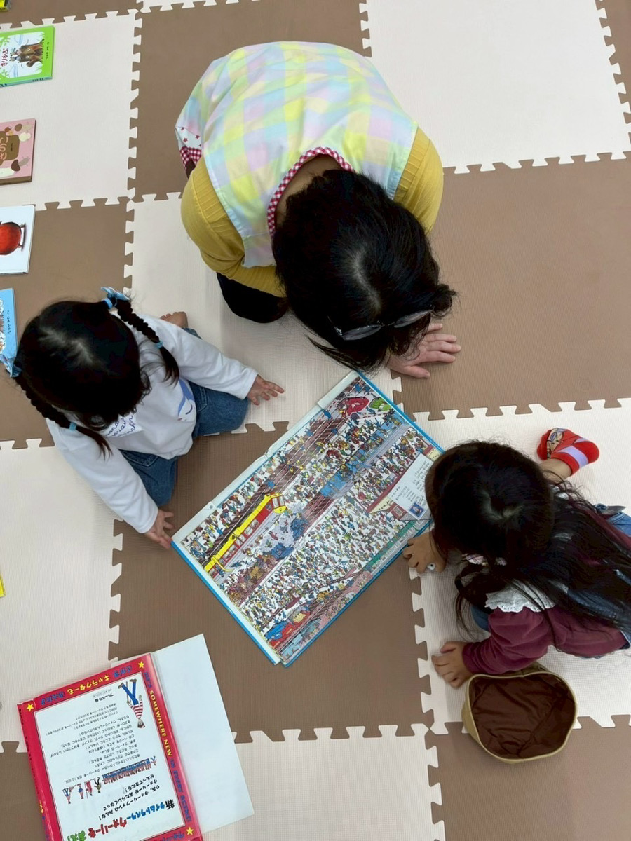 絵本を楽しむ子どもたちと保育スタッフ